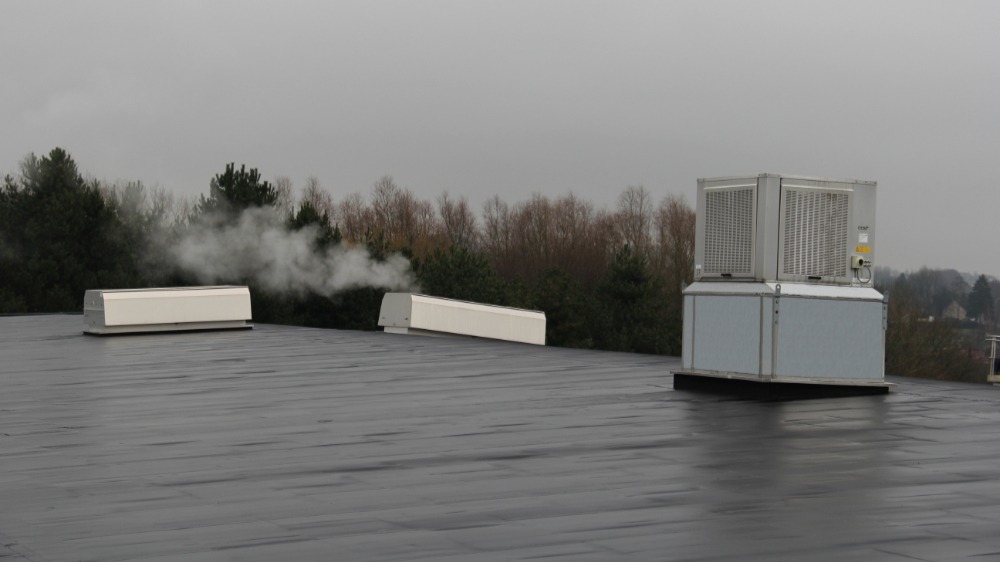 Op het dak staan twee buitenunits waar het inblaaskanaal via een opening in het dak gekoppeld wordt aan een luchtverdeelsysteem in de productieruimte. Ook staat hier een luchtmengsectie om op koudere dagen warmte te recupereren
